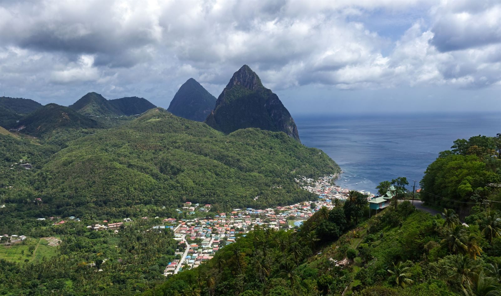 The twin Pitons rising above green hills and the town of Soufriere in St. Lucia